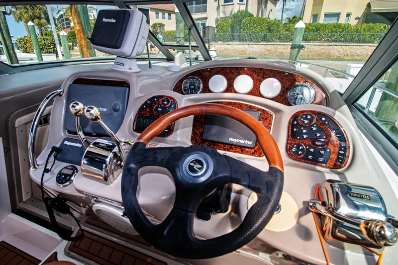 Slide: The Image of 2006 Sea Ray Sundancer 320 helm with Raymarine electronics and wood-accented dashboard. - 15