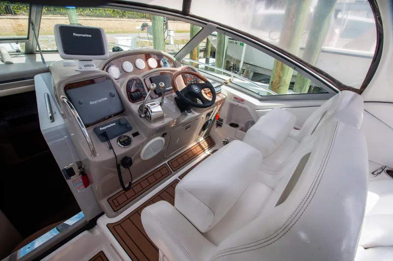 Slide: The Image of 2006 Sea Ray Sundancer 320 helm with Raymarine electronics and white seating. - 16