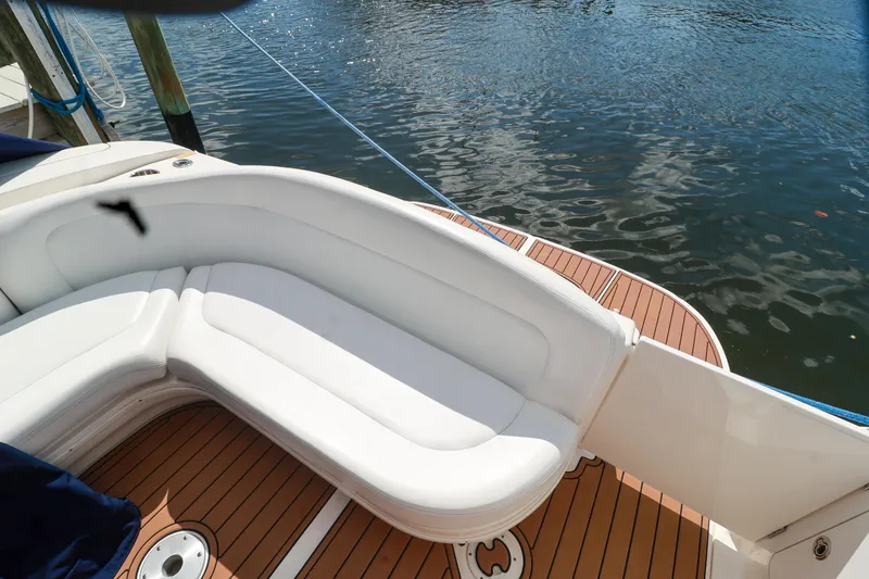 Slide: The Image of 2006 Sea Ray Sundancer 320 boat with white seating and teak deck by the water. - 23