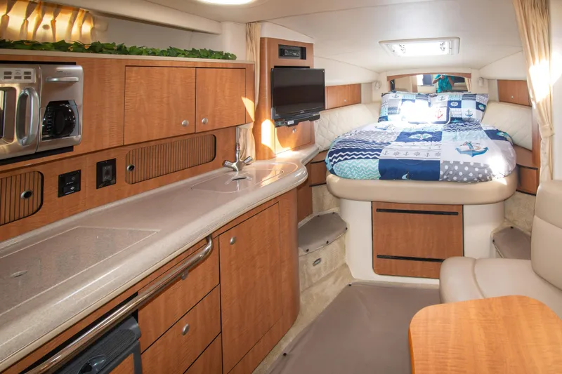 Slide: The Image of 2006 Sea Ray Sundancer 320 cabin interior with kitchenette and cozy bed. - 30