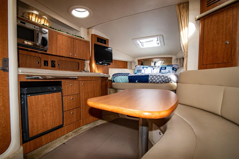 Slide: The Image of 2006 Sea Ray Sundancer 320 interior with kitchenette, seating, and bed. - 32