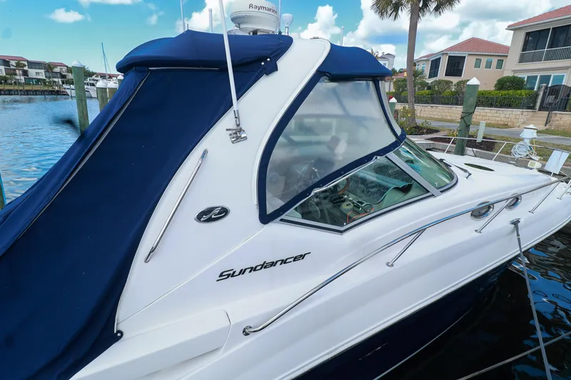 Slide: The Image of 2006 Sea Ray Sundancer 320 docked, featuring blue canopy and sleek design. - 4
