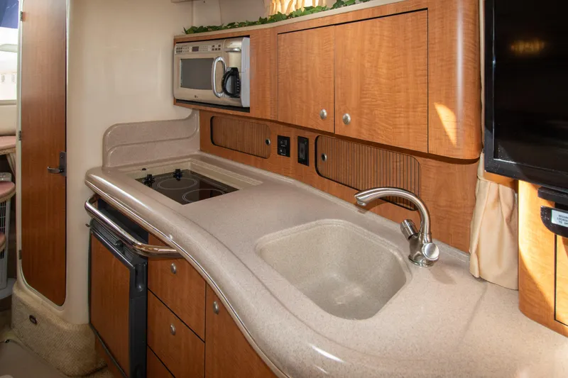Slide: The Image of 2006 Sea Ray Sundancer 320 interior kitchen with sink, stove, and microwave. - 40