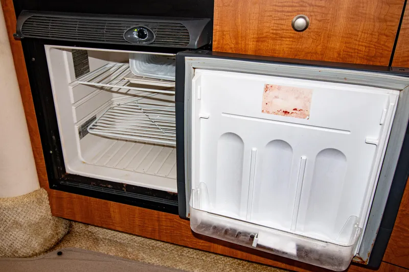 Slide: The Image of Open refrigerator inside 2006 Sea Ray Sundancer 320 boat, wooden cabinetry visible. - 46