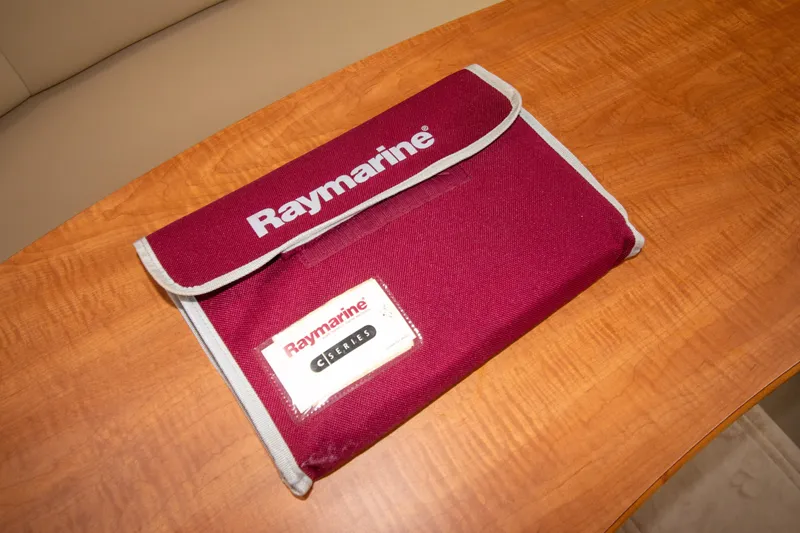 Slide: The Image of Red Raymarine case on wooden table, Sea Ray Sundancer 320, 2006 model. - 52