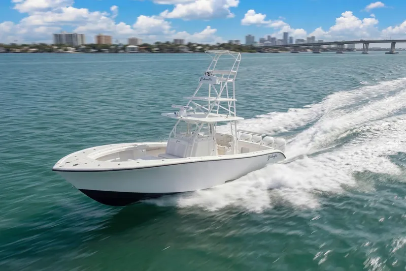 Slide: The Image of 2015 Yellowfin 39 Offshore boat cruising on open water with city skyline in background. - 11
