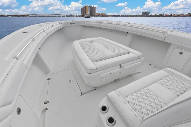 Slide: The Image of 2015 Yellowfin 39 Offshore boat interior with white cushioned seating and ocean view. - 14