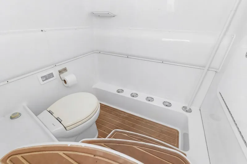 Slide: The Image of 2015 Yellowfin 39 Offshore boat bathroom with white fixtures and wooden flooring. - 9