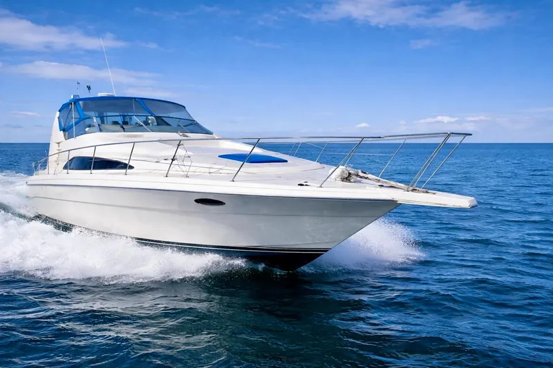 The Image of 1989 Bayliner 4285 Avanti cruising on open sea under clear blue sky. - 0