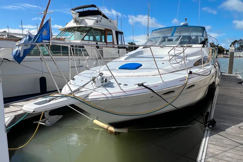 Slide: The Image of 1989 Bayliner 4285 Avanti yacht cruising on open sea under clear blue sky. - 2