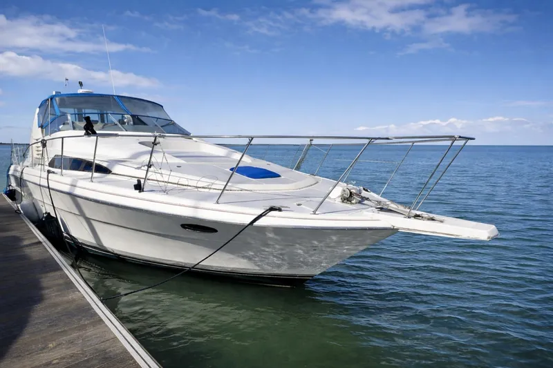 Slide: The Image of 1989 Bayliner 4285 Avanti yacht docked on calm blue water under clear sky. - 40