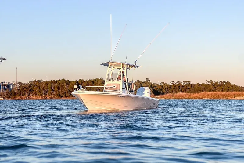 Slide: The Image of 2024 Pathfinder 2600 TRS boat on calm water at sunset. - 10