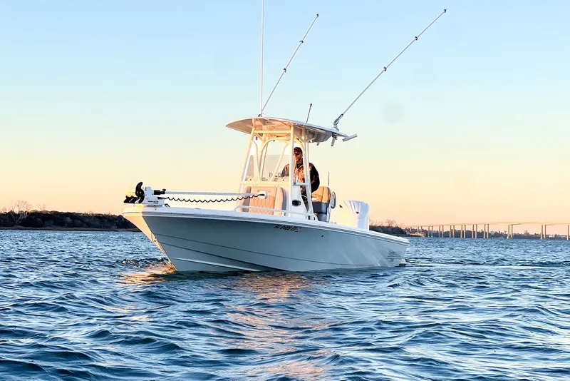 Slide: The Image of 2024 Pathfinder 2600 TRS boat on calm water at sunset. - 7