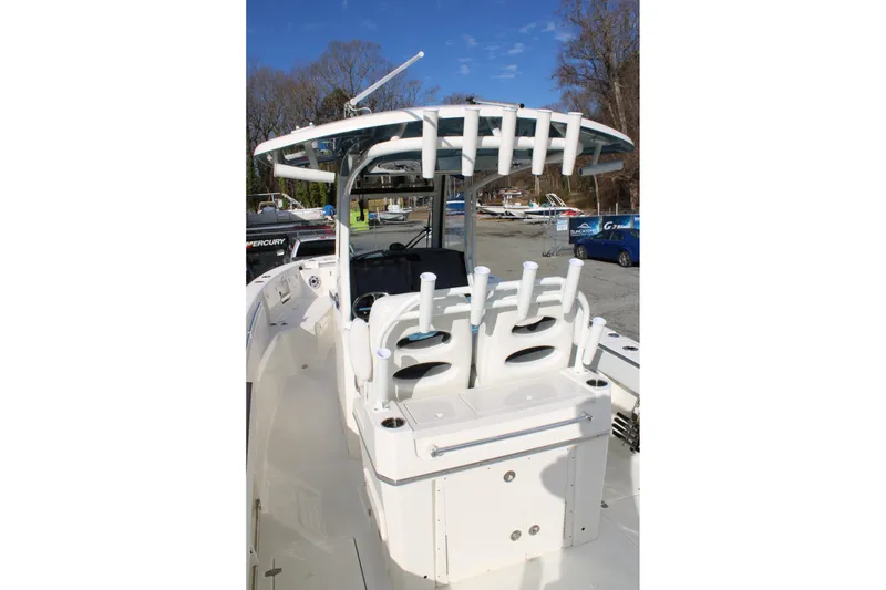 Slide: The Image of 2026 Cobia 285 Center Console boat with rod holders and seating, docked outdoors. - 10