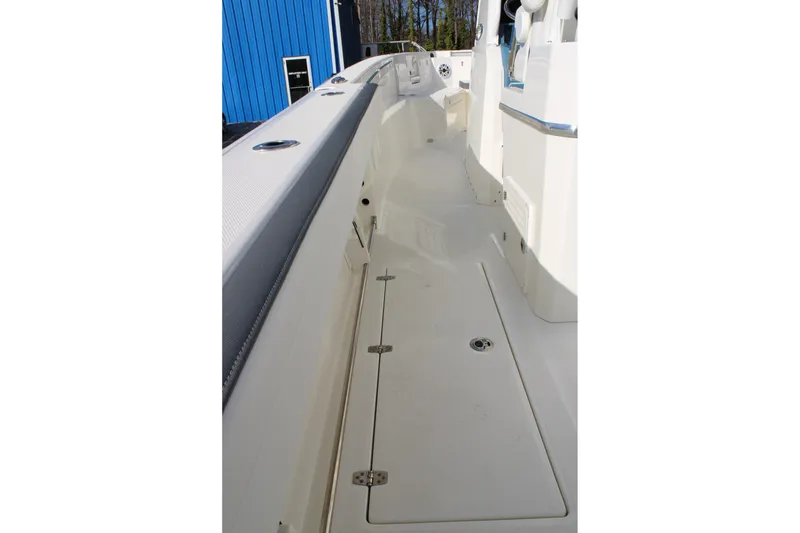 Slide: The Image of 2026 Cobia 285 Center Console boat interior, featuring sleek white deck and storage compartments. - 11