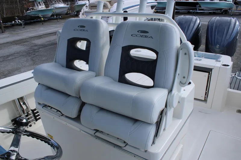 Slide: The Image of 2026 Cobia 285 Center Console boat with dual cushioned seats and steering wheel. - 24