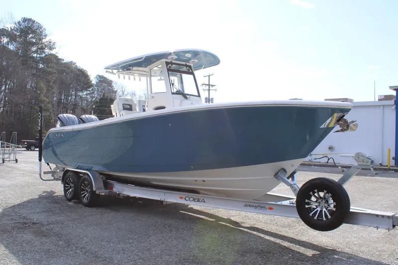 Slide: The Image of 2026 Cobia 285 Center Console boat on trailer, parked outdoors. - 6