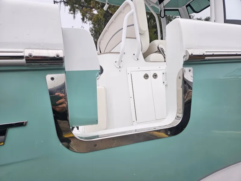 Slide: The Image of 2023 Sea Hunt Escape 28 boat interior with storage compartments and twin engines. - 10