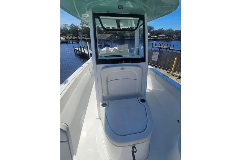 Slide: The Image of 2023 Sea Hunt Escape 28 boat interior with seating, docked by a calm waterfront. - 31