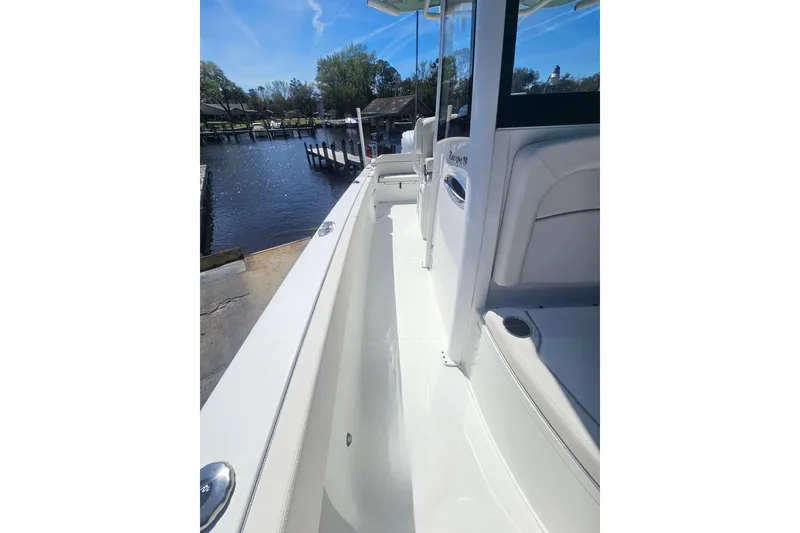 Slide: The Image of 2023 Sea Hunt Escape 28 boat docked by a serene waterfront. - 33