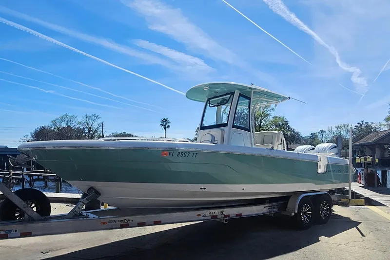 Slide: The Image of 2023 Sea Hunt Escape 28 boat on trailer under clear blue sky. - 35