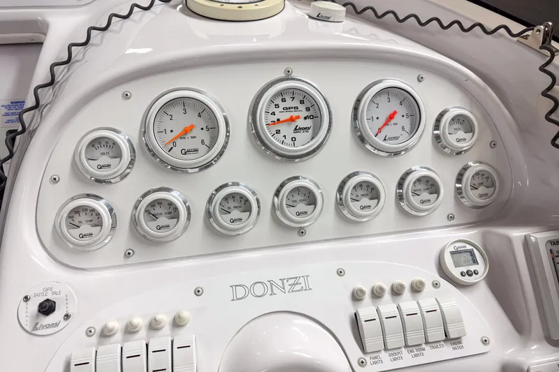 Slide: The Image of Dashboard of a 2002 Donzi 38 ZX boat with multiple gauges and controls. - 13