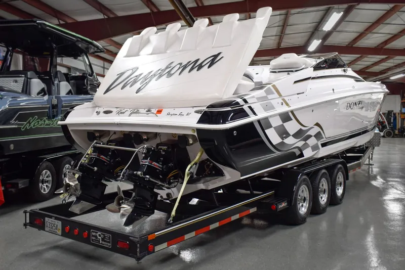 Slide: The Image of 2002 Donzi 38 ZX powerboat on trailer in indoor showroom, featuring sleek design and twin engines. - 2