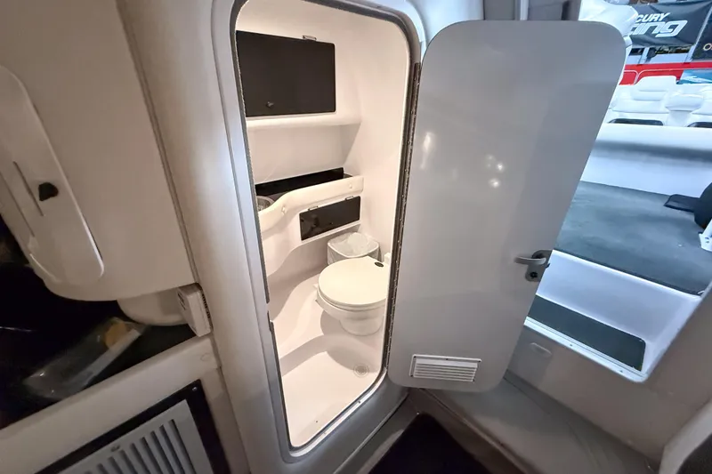 Slide: The Image of Interior of 2002 Donzi 38 ZX boat showing compact bathroom with toilet and storage. - 31