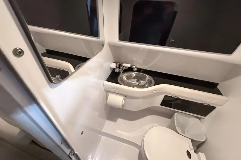 Slide: The Image of 2002 Donzi 38 ZX boat bathroom with sink, toilet, and storage. - 32