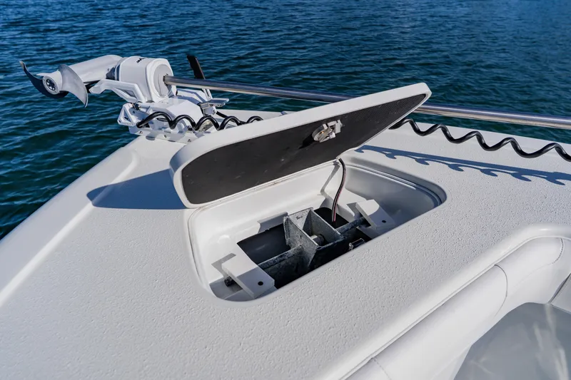 Slide: The Image of 2025 Yellowfin 36 Offshore boat anchor compartment with open lid on calm water. - 11