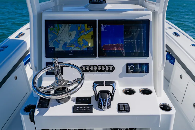 Slide: The Image of 2025 Yellowfin 36 Offshore boat dashboard with navigation screens and steering wheel. - 32