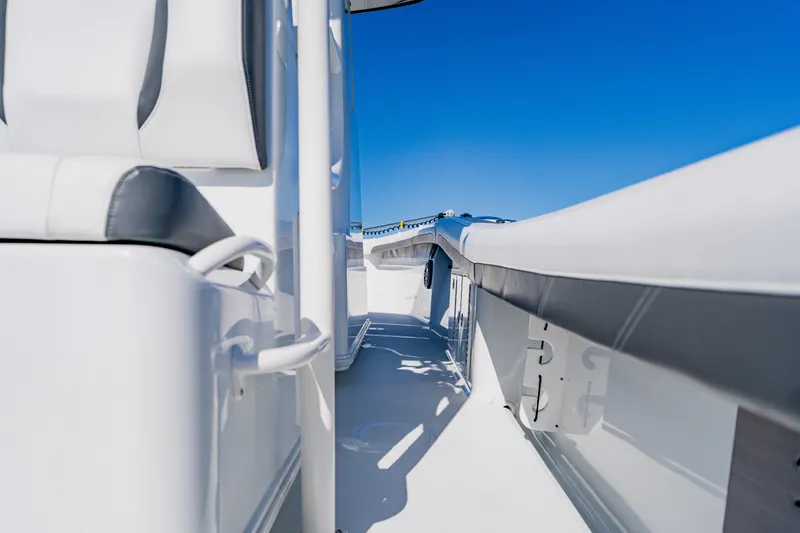 Slide: The Image of 2025 Yellowfin 36 Offshore boat interior with sleek white seating and bright blue sky. - 34