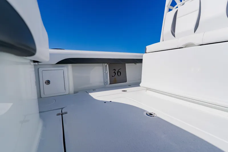 Slide: The Image of 2025 Yellowfin 36 Offshore boat interior with seating and storage, under clear blue sky. - 42