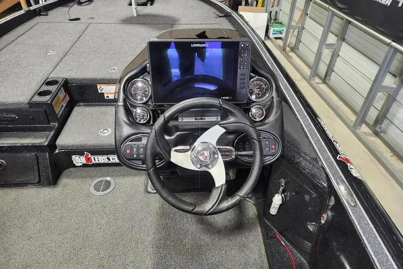 Slide: The Image of 2019 Triton 21 TrX boat cockpit with steering wheel and Lowrance display. - 8