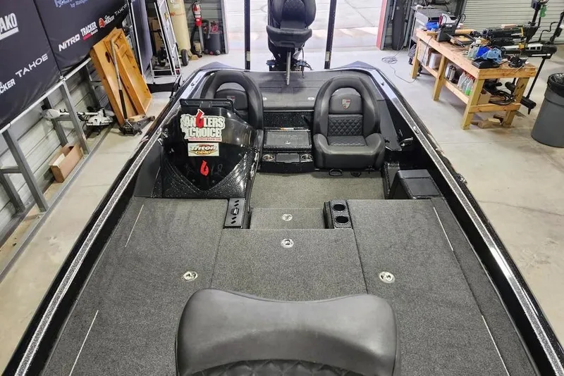 Slide: The Image of 2019 Triton 21 TrX boat interior in a workshop, featuring seating and storage compartments. - 9