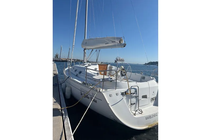 Slide: The Image of 1999 Beneteau Oceanis 321 sailboat docked at marina, clear blue sky. - 13