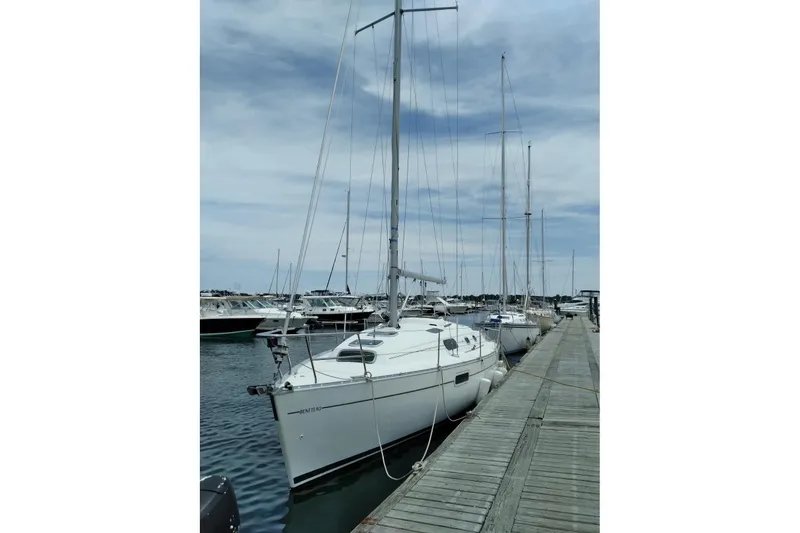 Slide: The Image of 1999 Beneteau Oceanis 321 sailboat docked at a marina under a cloudy sky. - 15