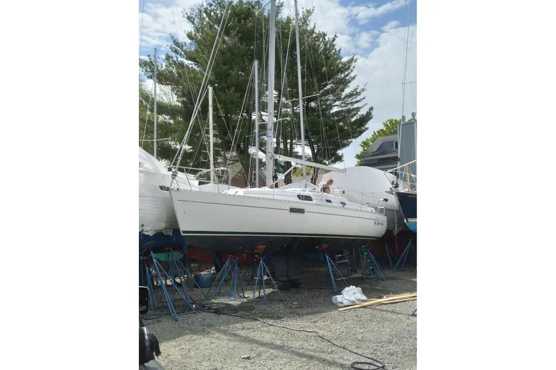 Slide: The Image of 1999 Beneteau Oceanis 321 sailboat on stands, surrounded by trees and clear sky. - 16