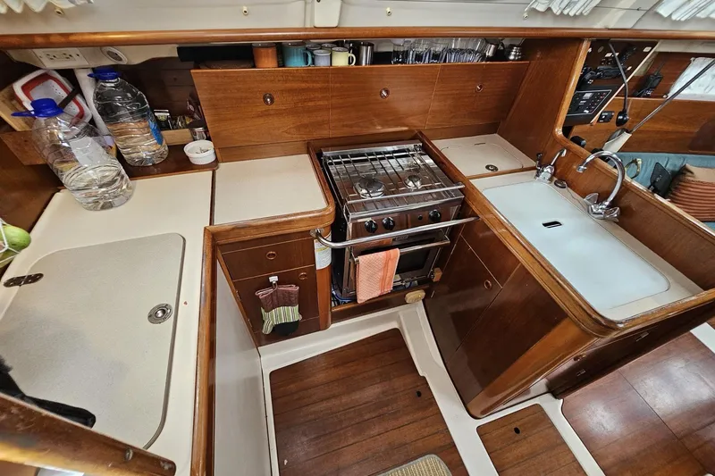 Slide: The Image of Interior view of 1999 Beneteau Oceanis 321 yacht kitchen with stove, sink, and wooden cabinetry. - 6