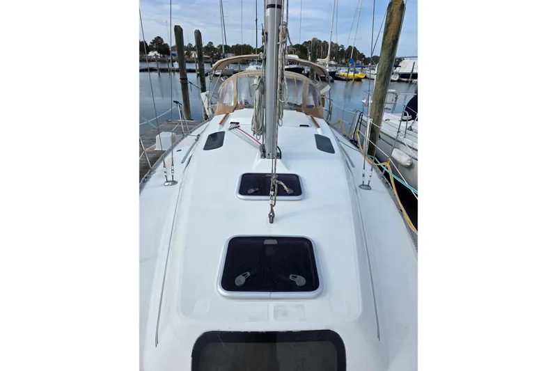 Slide: The Image of 1999 Beneteau Oceanis 321 sailboat docked at marina, showcasing deck and hatches. - 8