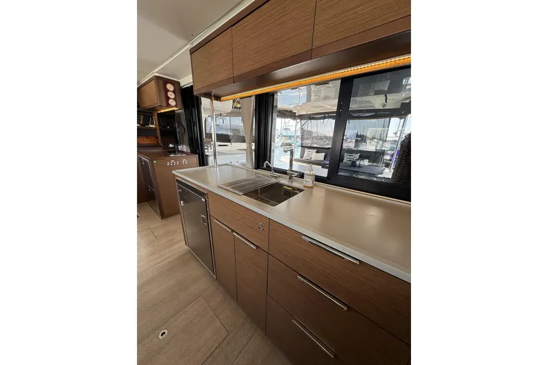 Slide: The Image of Modern kitchen interior of 2020 Lagoon 46 yacht with sleek wood cabinetry and stainless steel appliances. - 13