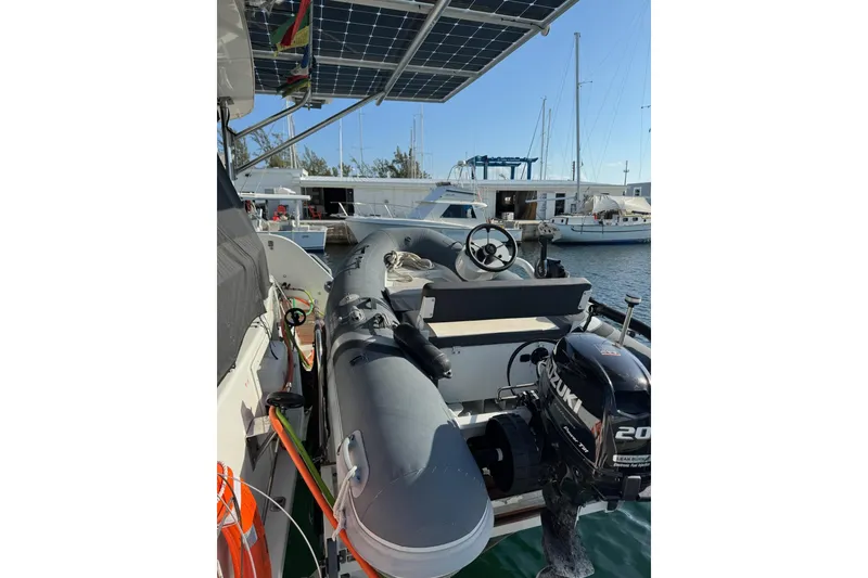 Slide: The Image of 2020 Lagoon 46 yacht with inflatable boat and Suzuki outboard motor at marina. - 43