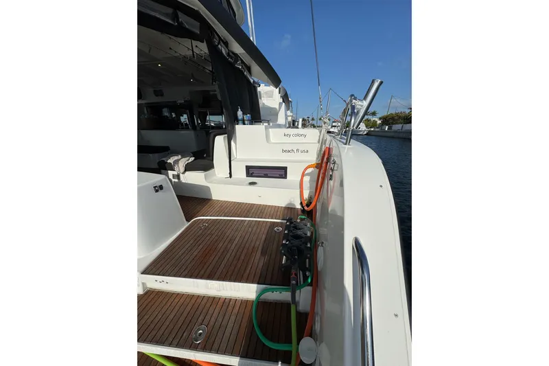 Slide: The Image of 2020 Lagoon 46 yacht deck with wooden flooring and marina view. - 45