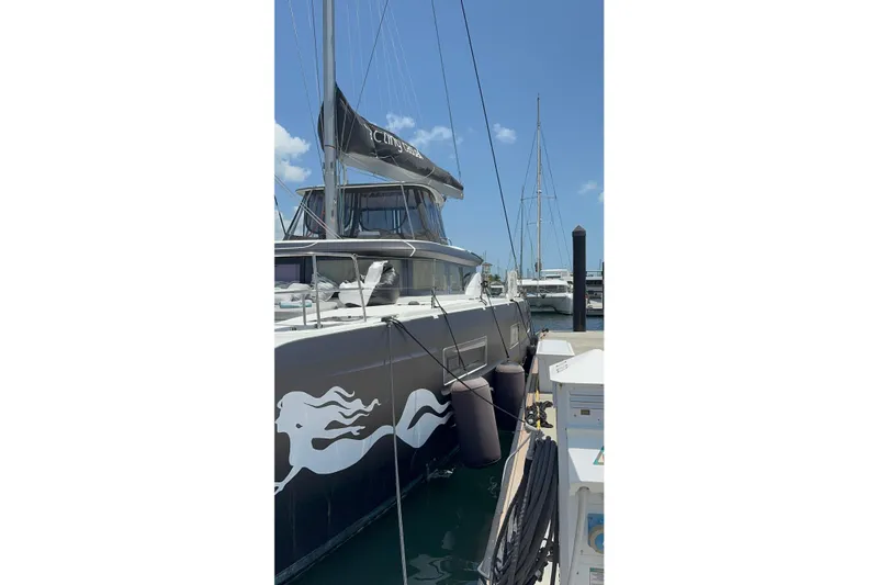Slide: The Image of 2020 Lagoon 46 catamaran docked at marina, featuring sleek design and nautical graphics. - 47