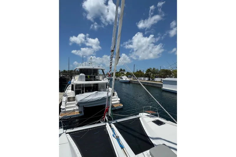Slide: The Image of Lagoon 46 catamaran docked in a marina, clear blue sky, 2020 model. - 52