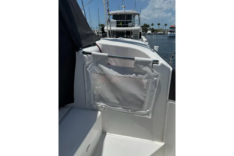 Slide: The Image of 2020 Lagoon 46 yacht deck with storage pocket, docked in sunny marina. - 55