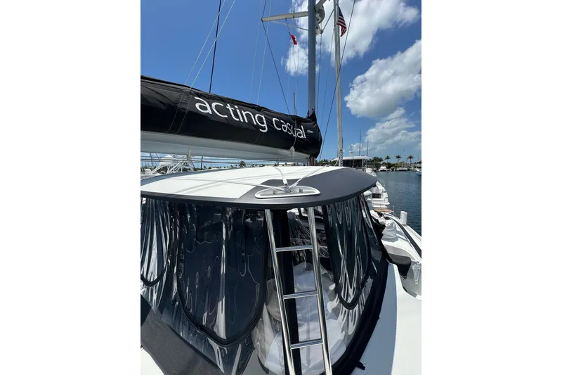 Slide: The Image of 2020 Lagoon 46 catamaran with sails, docked under a clear blue sky. - 57
