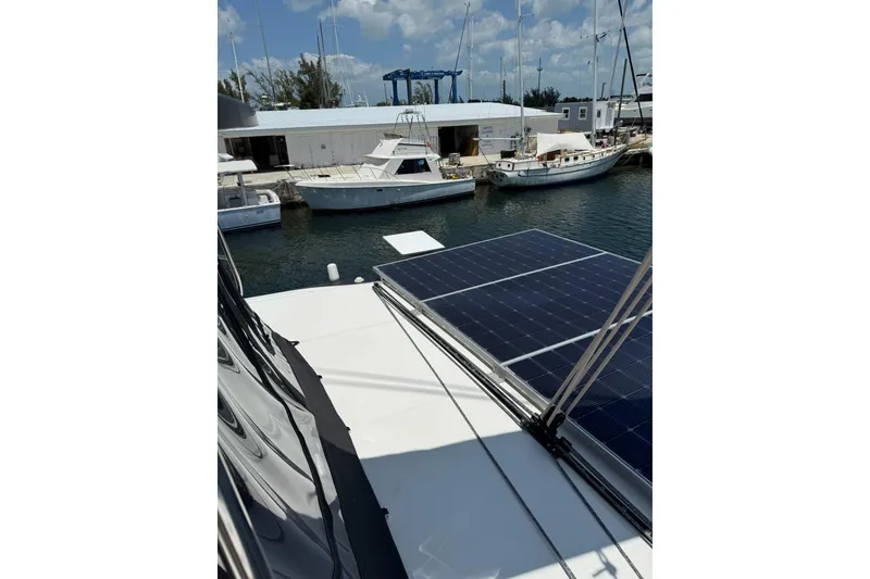 Slide: The Image of 2020 Lagoon 46 catamaran with solar panels docked at a marina. - 59
