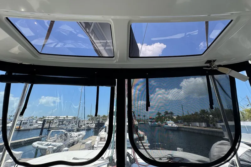 Slide: The Image of Interior view from a 2020 Lagoon 46 catamaran, showcasing marina and sky through windows. - 60