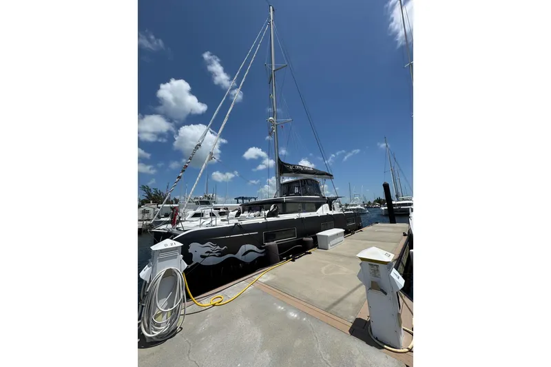 Slide: The Image of 2020 Lagoon 46 catamaran docked at marina under clear blue sky. - 67